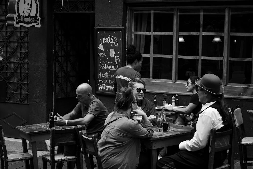 Black and white photo of people enjoying leisure time at a café in Bogotá.