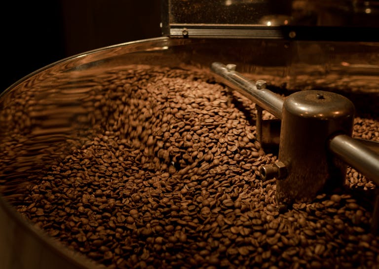 Freshly roasted coffee beans in motion inside a roaster.
